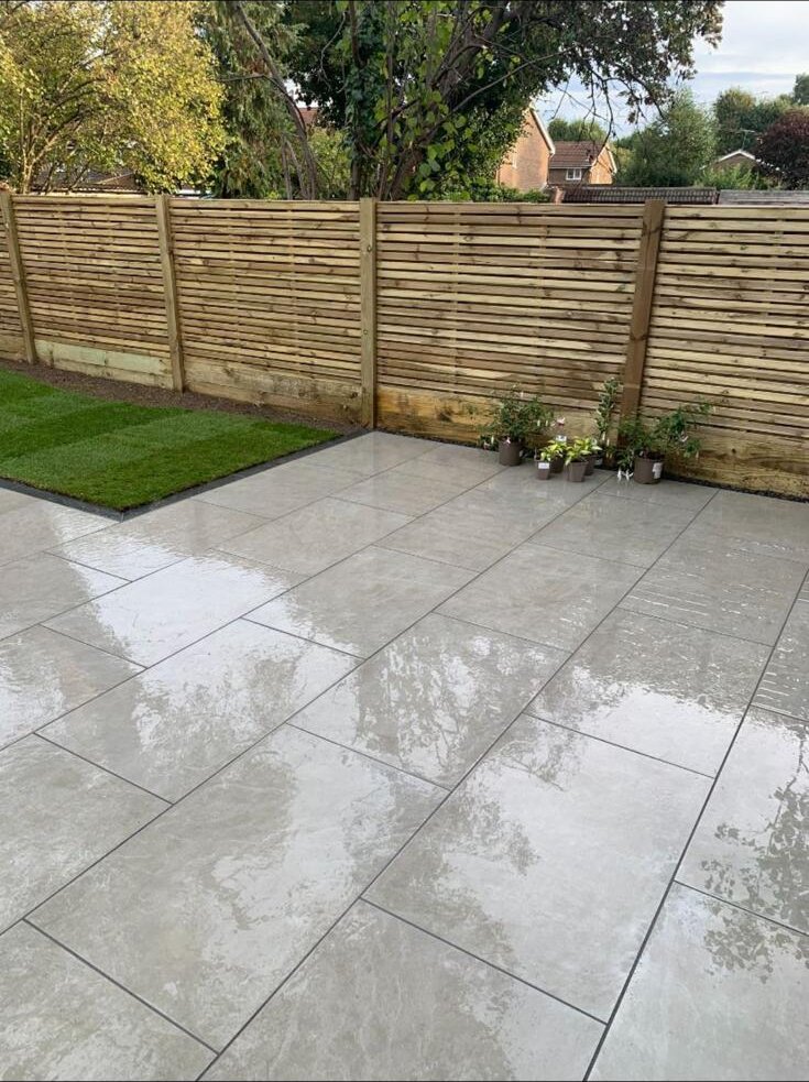 AMG Landscapes porcelain patio with new fencing and lawn edging Porcelain patio with fencing and lawn edging